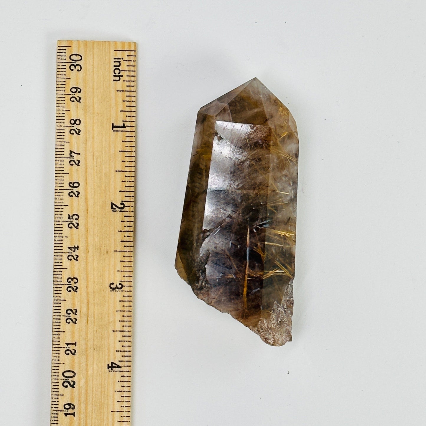 rutilated quarts next to a ruler for size reference