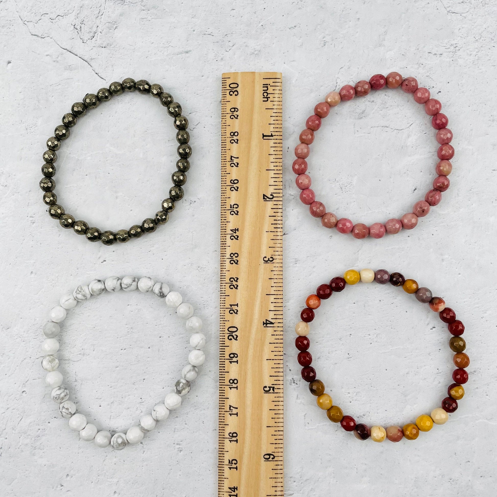 bracelets next to a ruler for size reference 