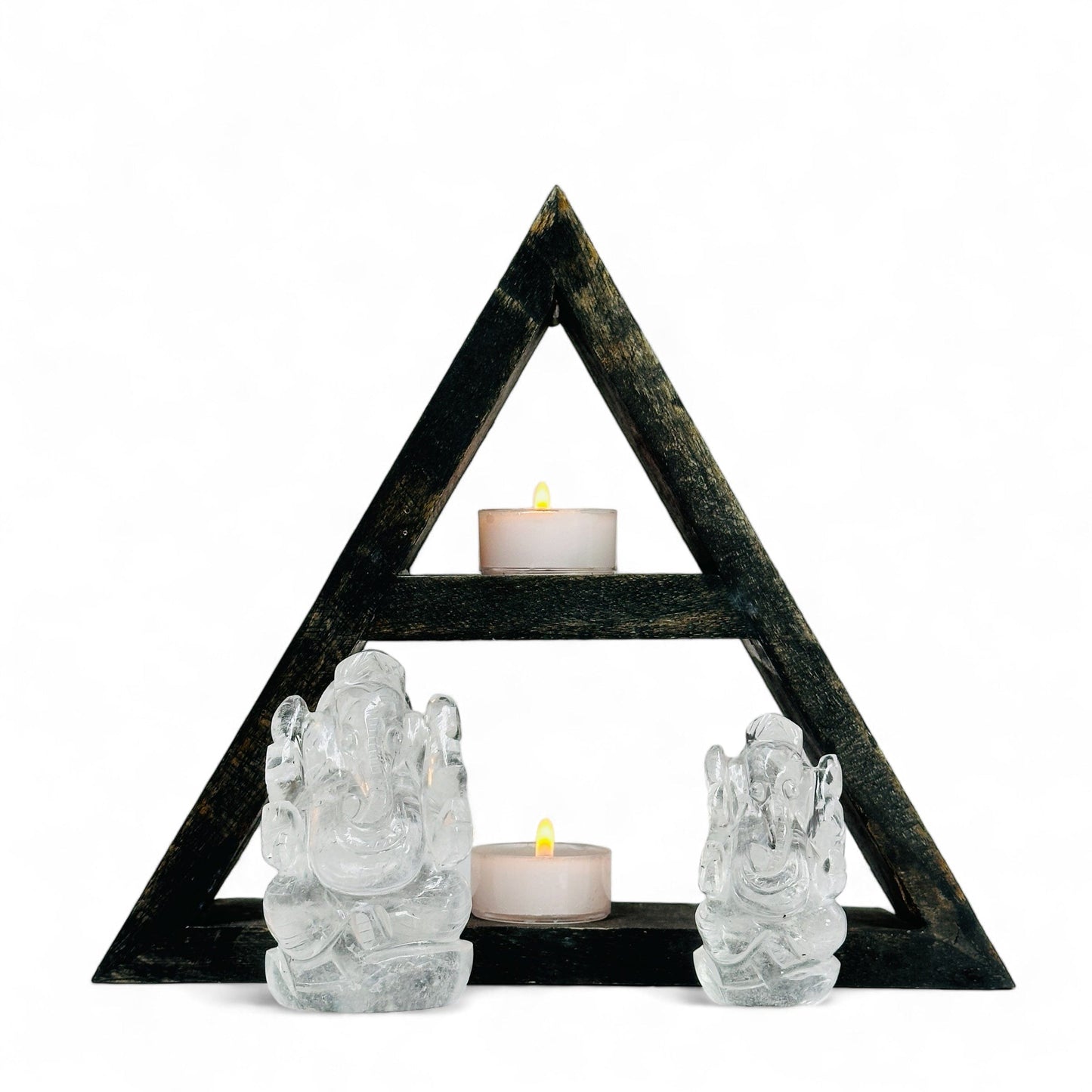 Ganesha Elephant crystal Quartz Carvings in front of a wood shelf holding 2 candles with a white background.