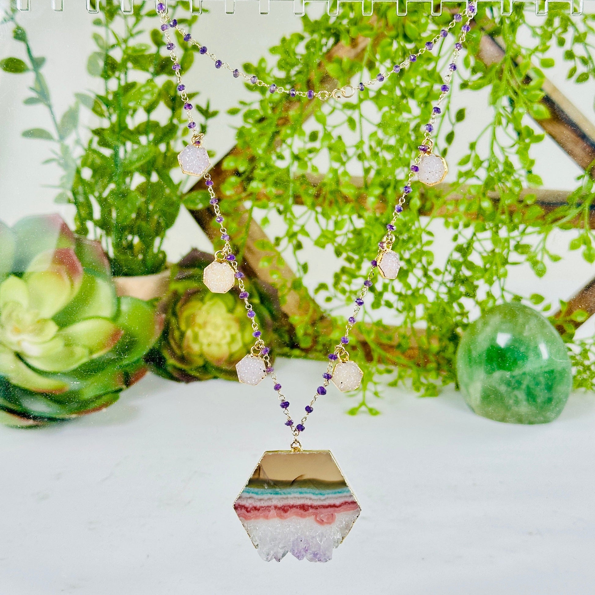 Amethyst Hexagon Crystal Charm Necklace with Amethyst Beaded Chain - Gold over Sterling Silver with props and plants in the background