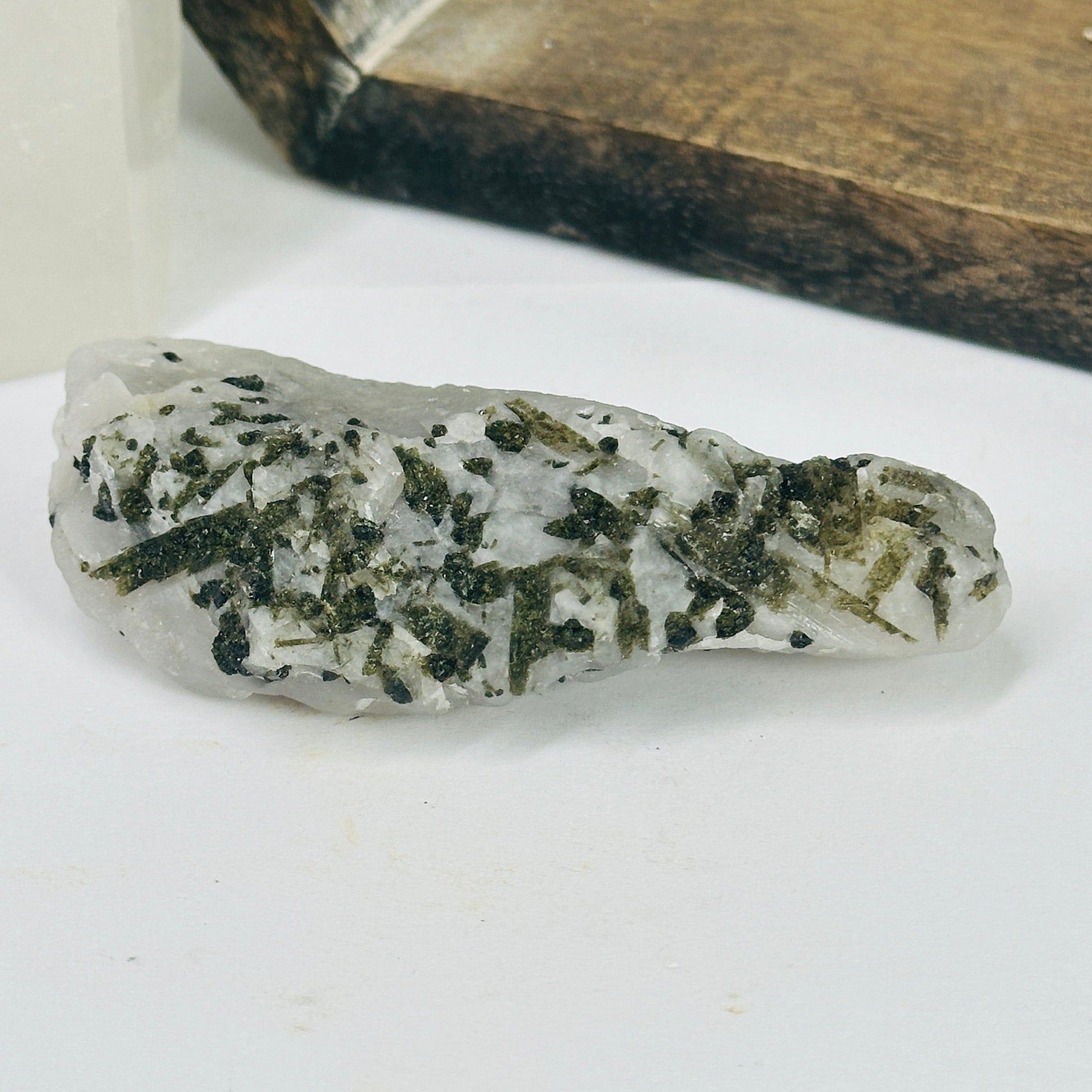 epidote on matrix with decorations in the background