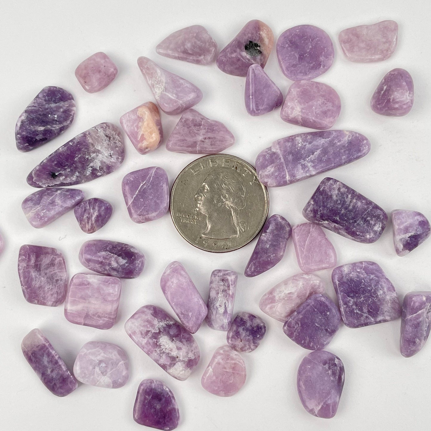 tumbled stones next to a quarter for size reference 