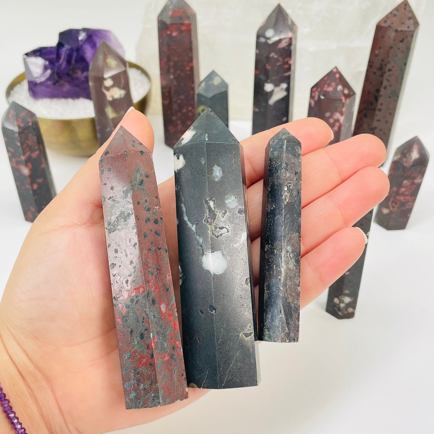 plum blossom jasper polished points in hand for size reference 
