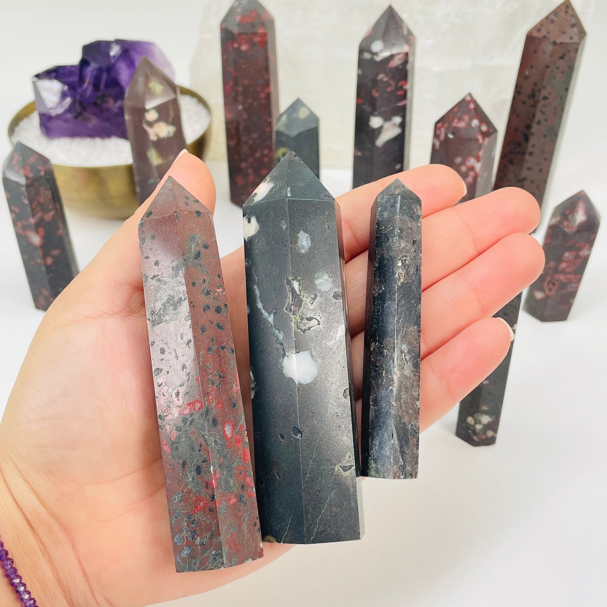 plum blossom jasper polished points in hand for size reference 