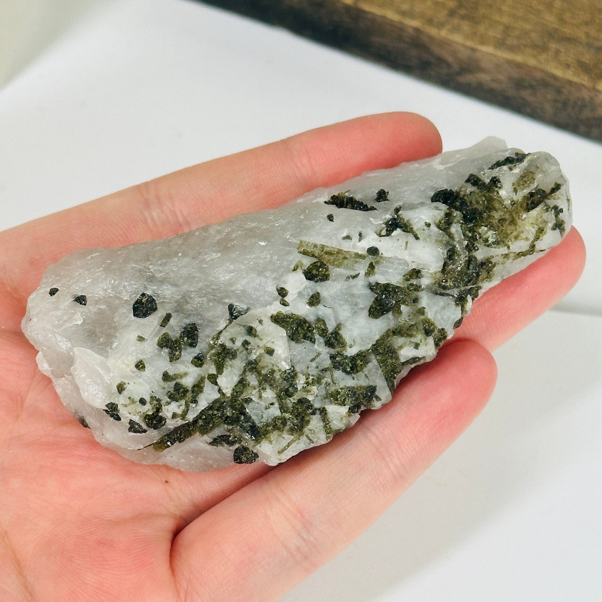 epidote on matrix with decorations in the background