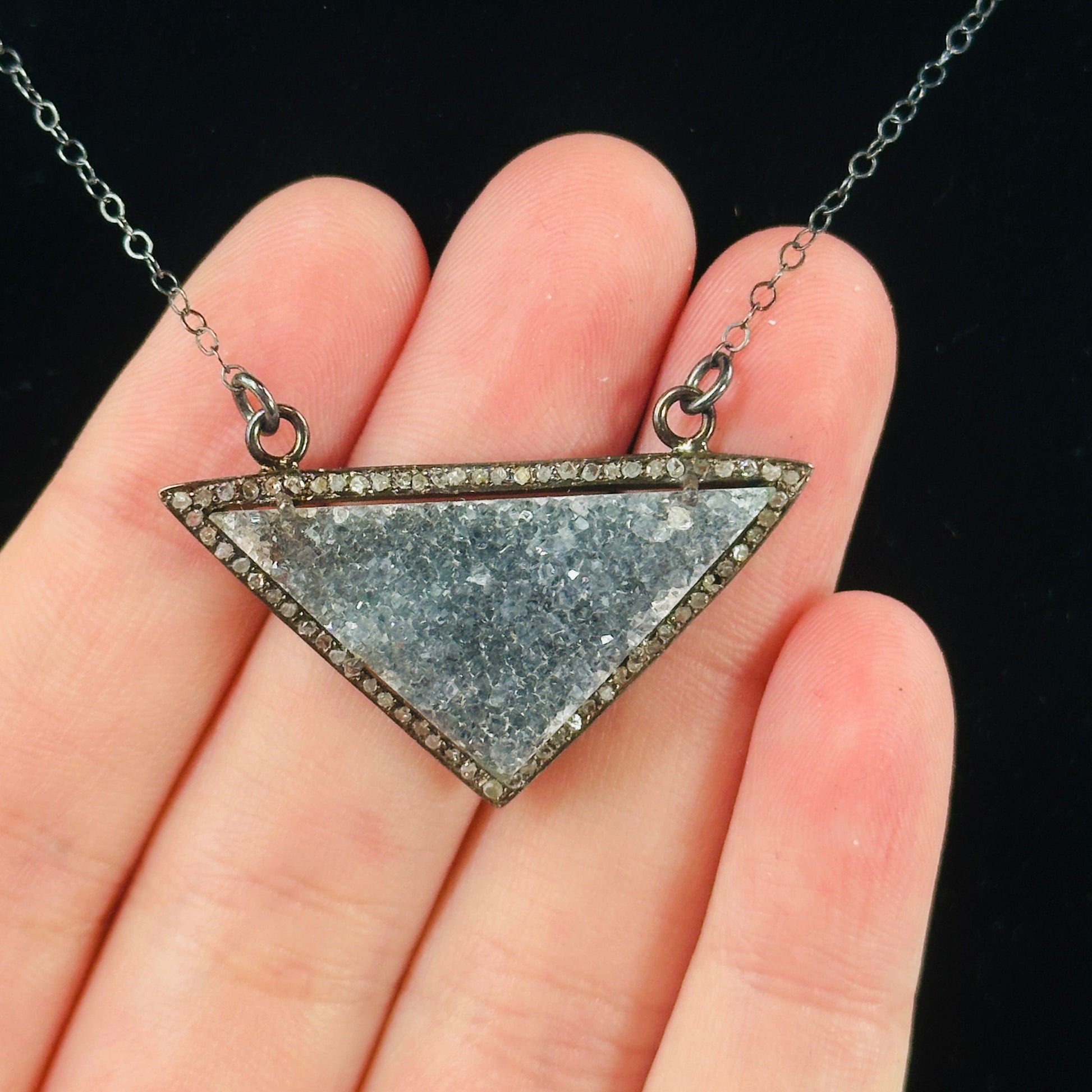 hand holding up druzy pendant on necklace