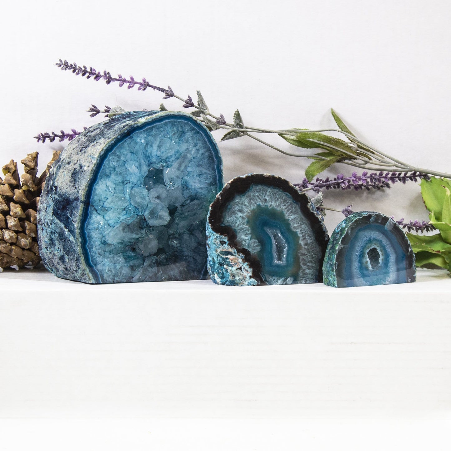 Three different sized agate Half Geode Druzy in an alter with a white background. Displaying variation in size, color and pattern.