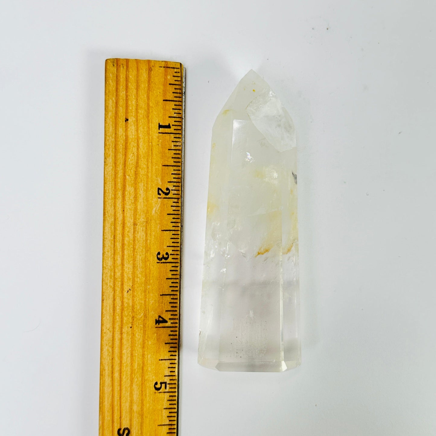 crystal quartz point next to a ruler for size reference