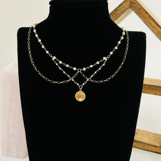 gold pearl necklace with decorations in the background