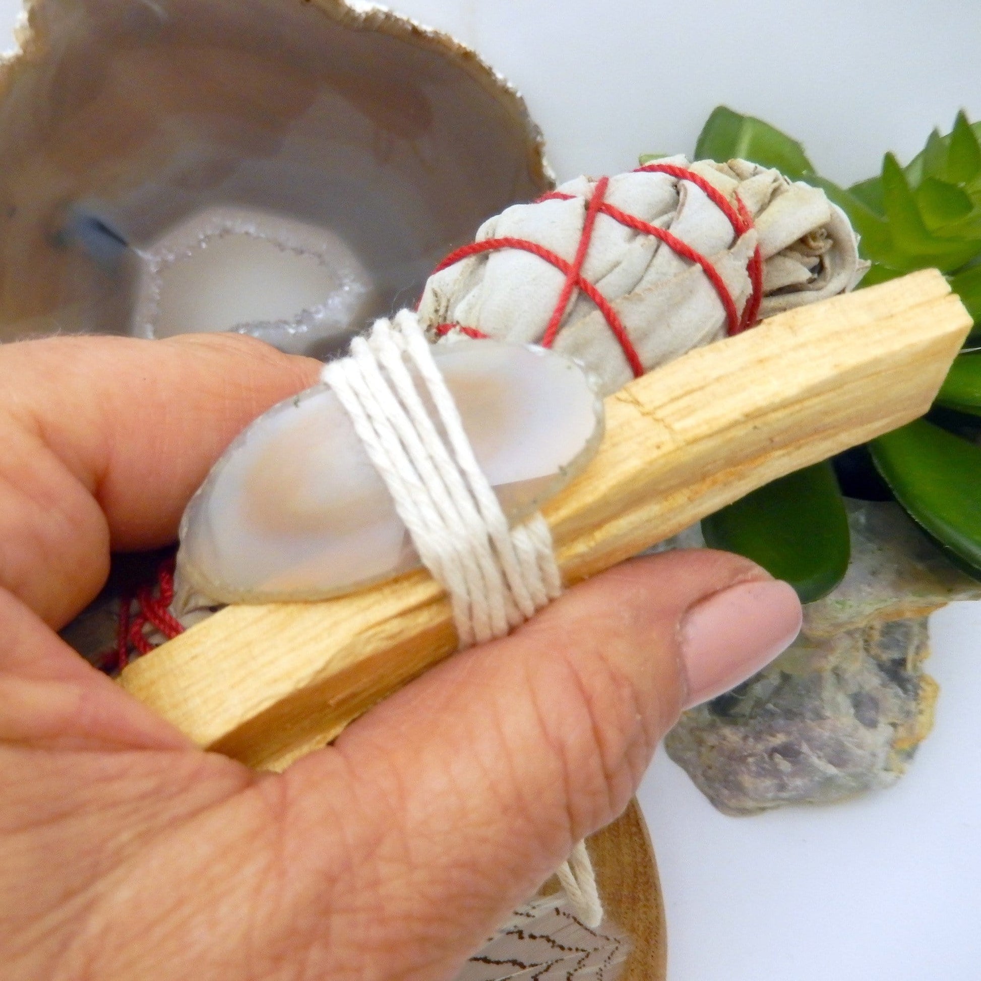 sage bundle with agate slice in hand for size reference and possible variation