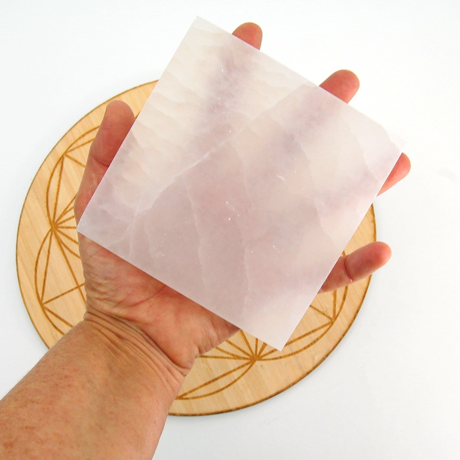 square selenite charging plate in hand for size reference