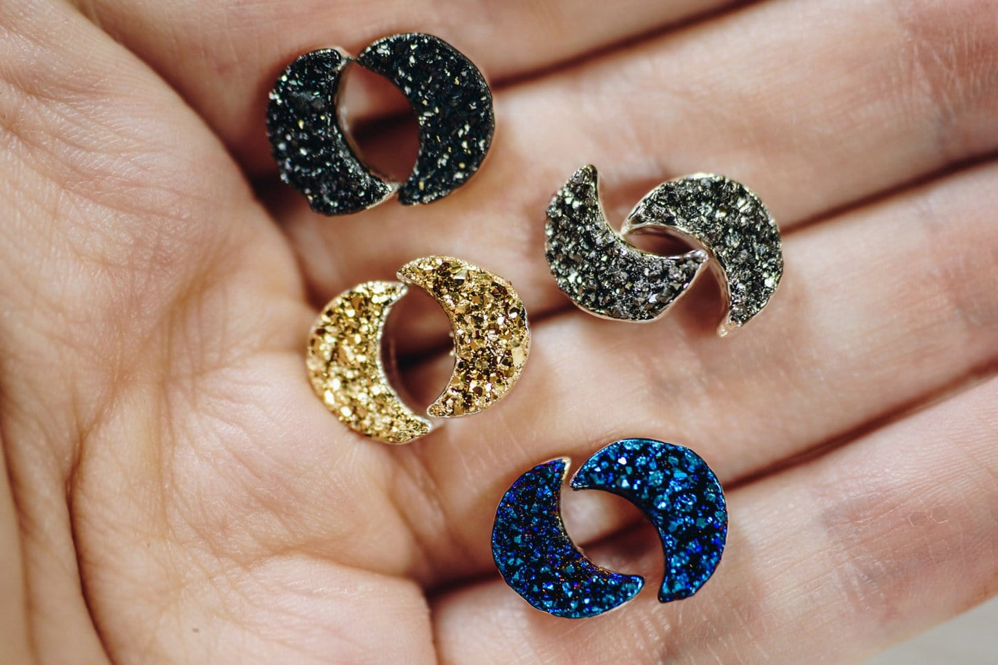 druzy moon earrings in a hand