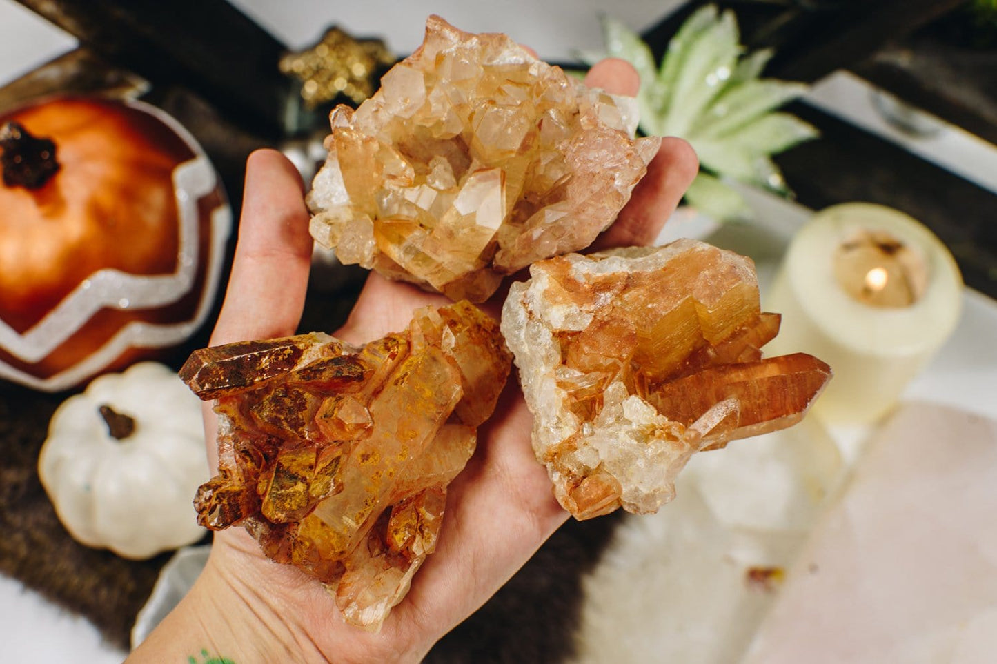 3 Tangerine Quartz Clusters held on a hand 