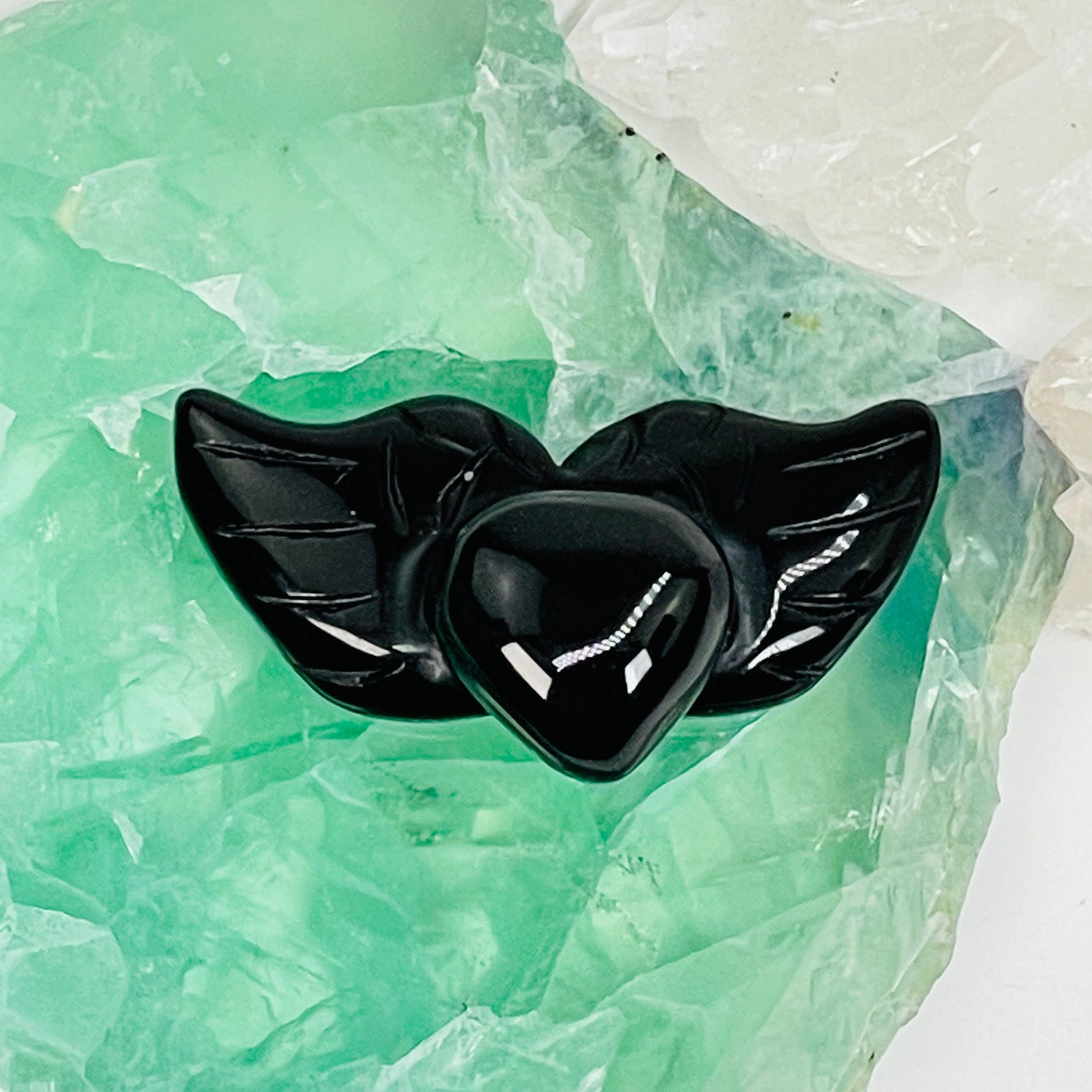 black obsidian heart with wings gemstone displayed as home decor 