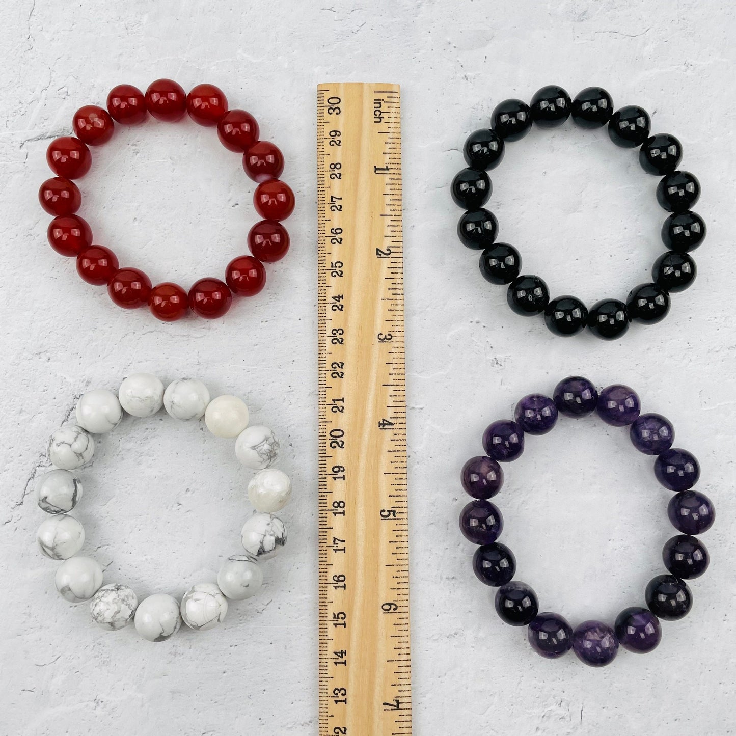 bracelets next to a ruler for size reference 