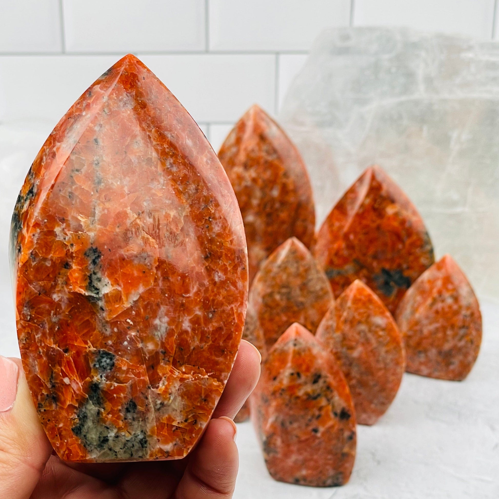 Orange Calcite Flame Point in hand for size reference 