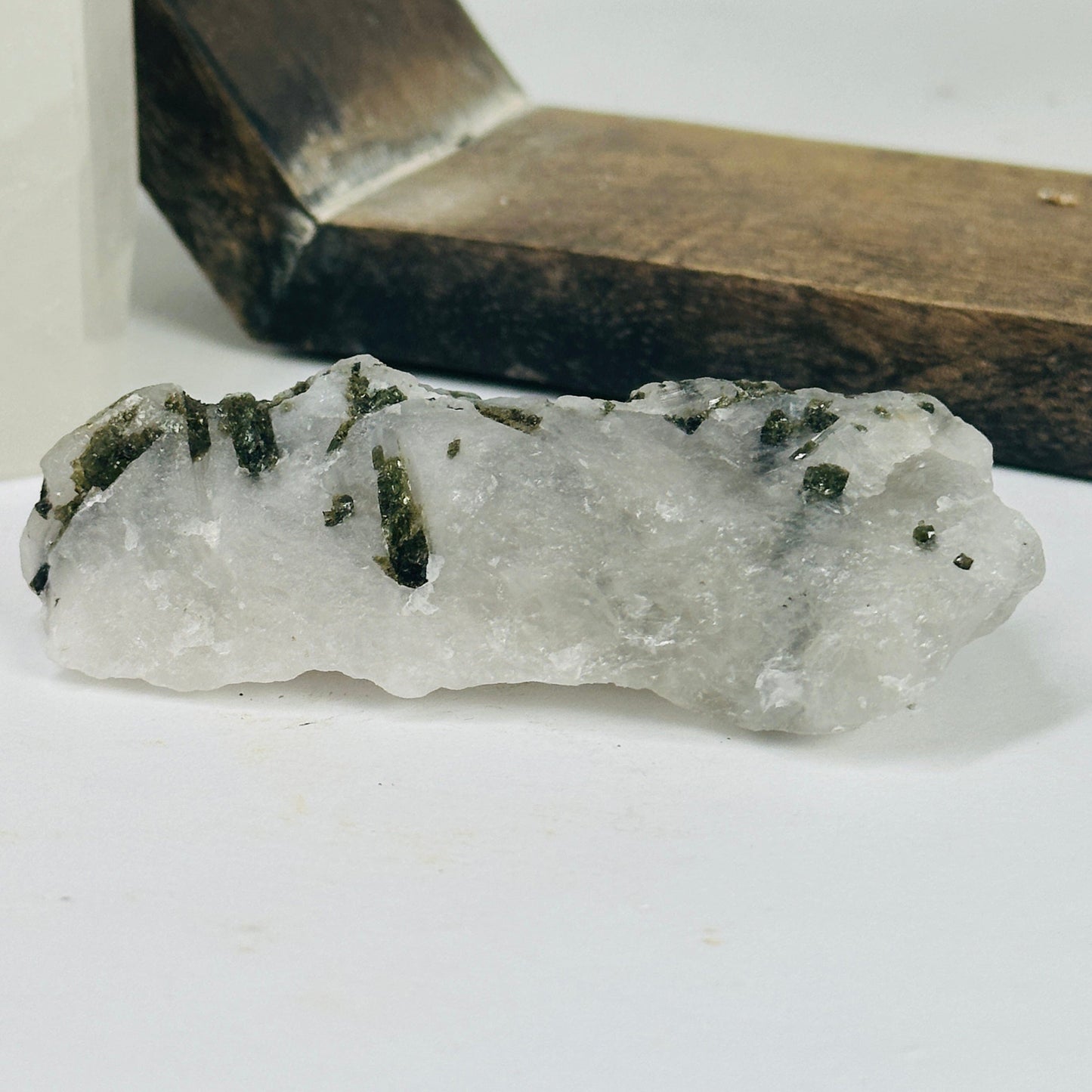 epidote on matrix with decorations in the background
