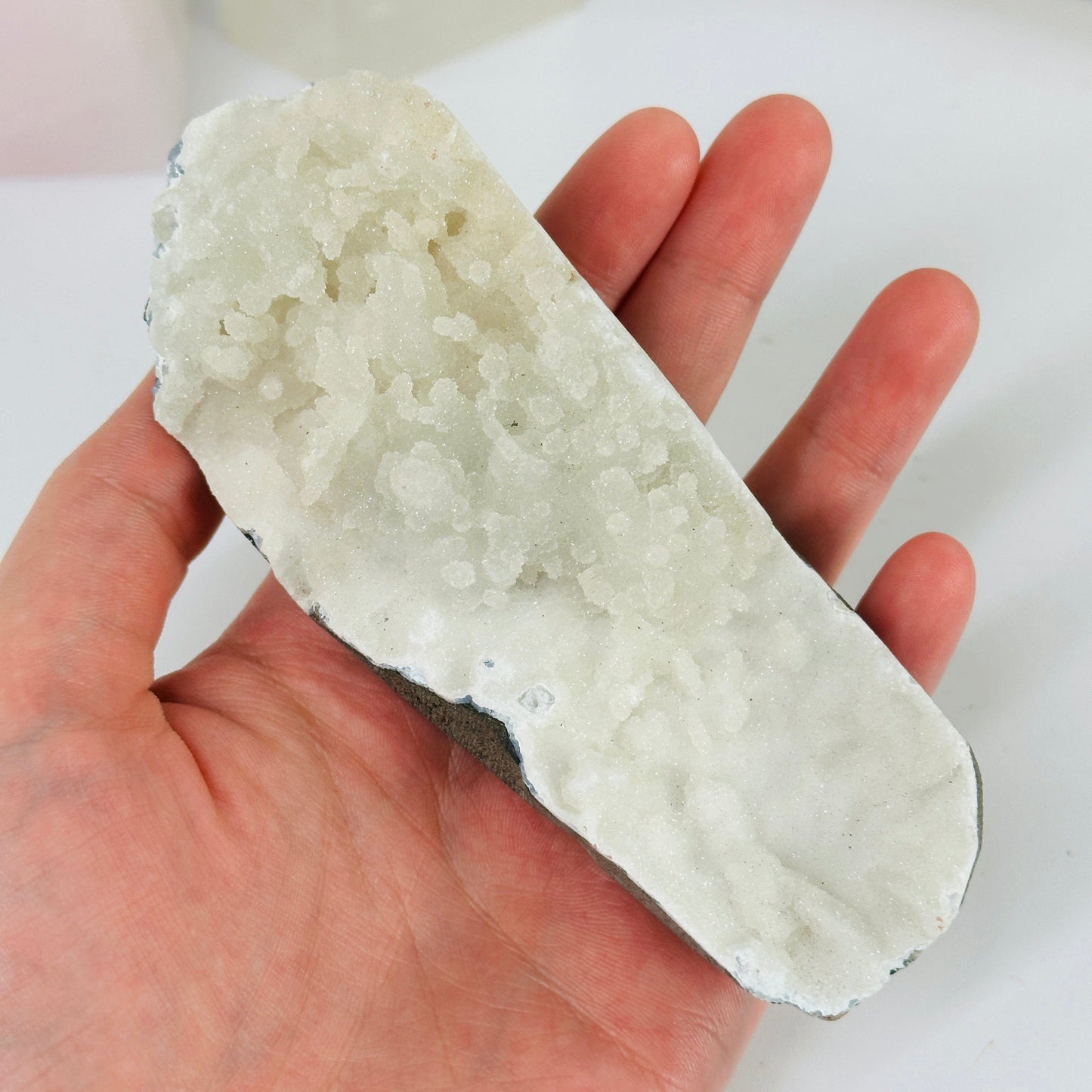 apophyllite on matrix with decorations in the background