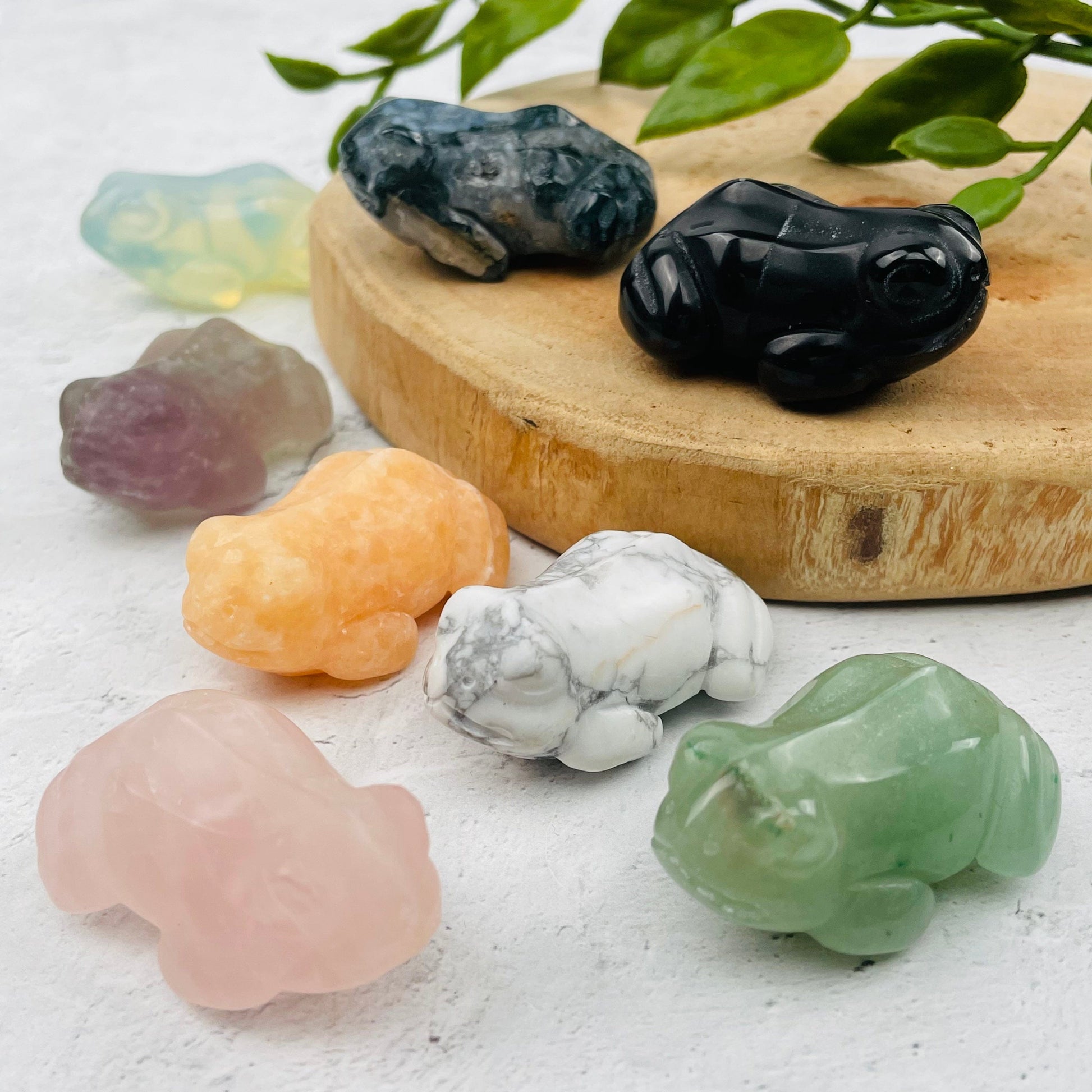 multiple carved crystal frogs displayed to show the differences in the color shades 