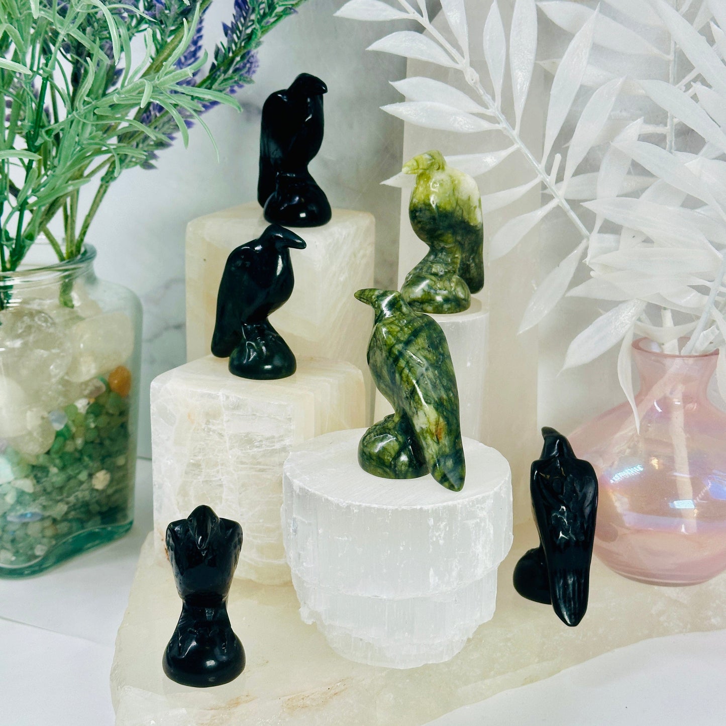 Gemstone Raven - Carved Raven - black obsidian and green jadeite ravens on white pedestals of different heights at different angles to show detail