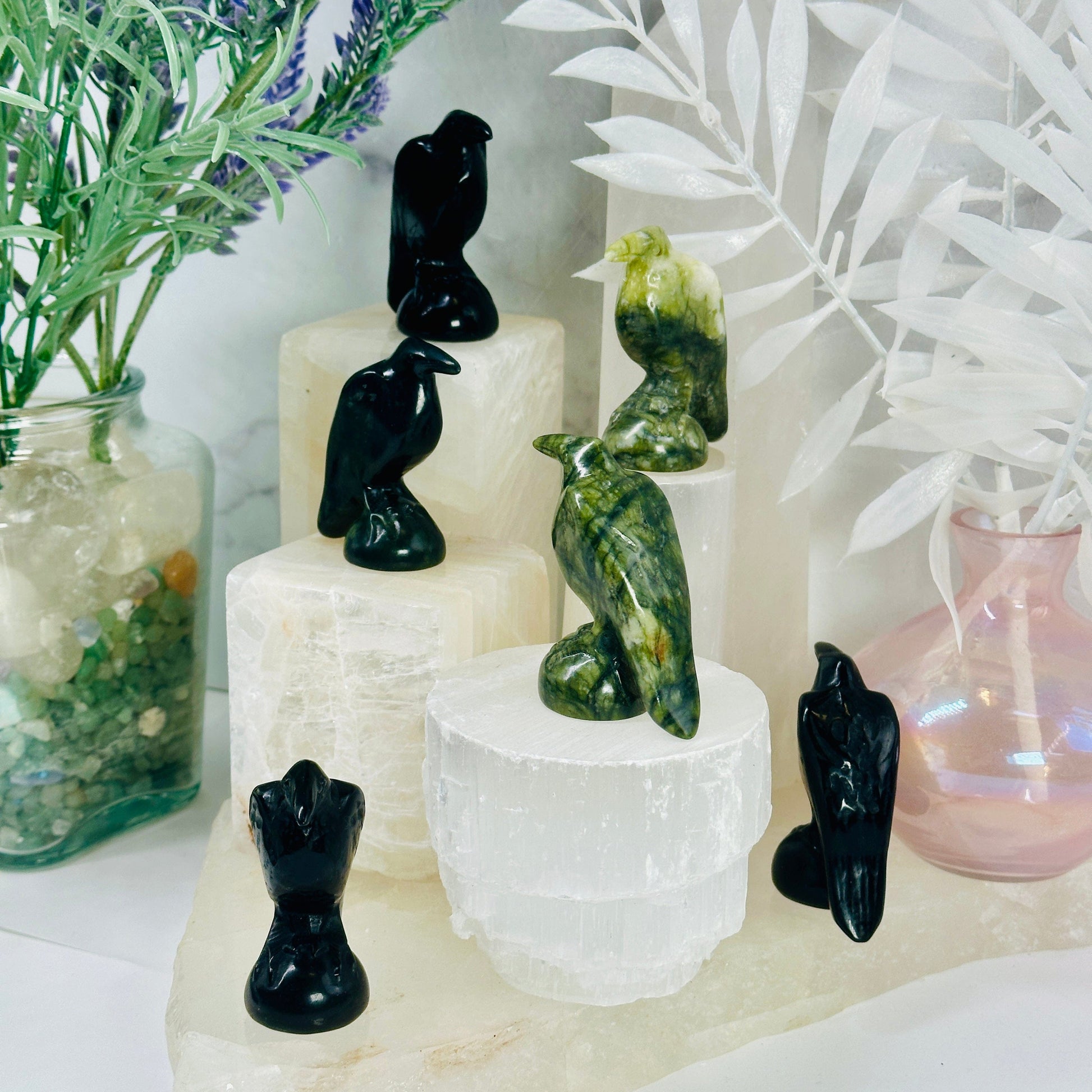 Gemstone Raven - Carved Raven - black obsidian and green jadeite ravens on white pedestals of different heights at different angles to show detail