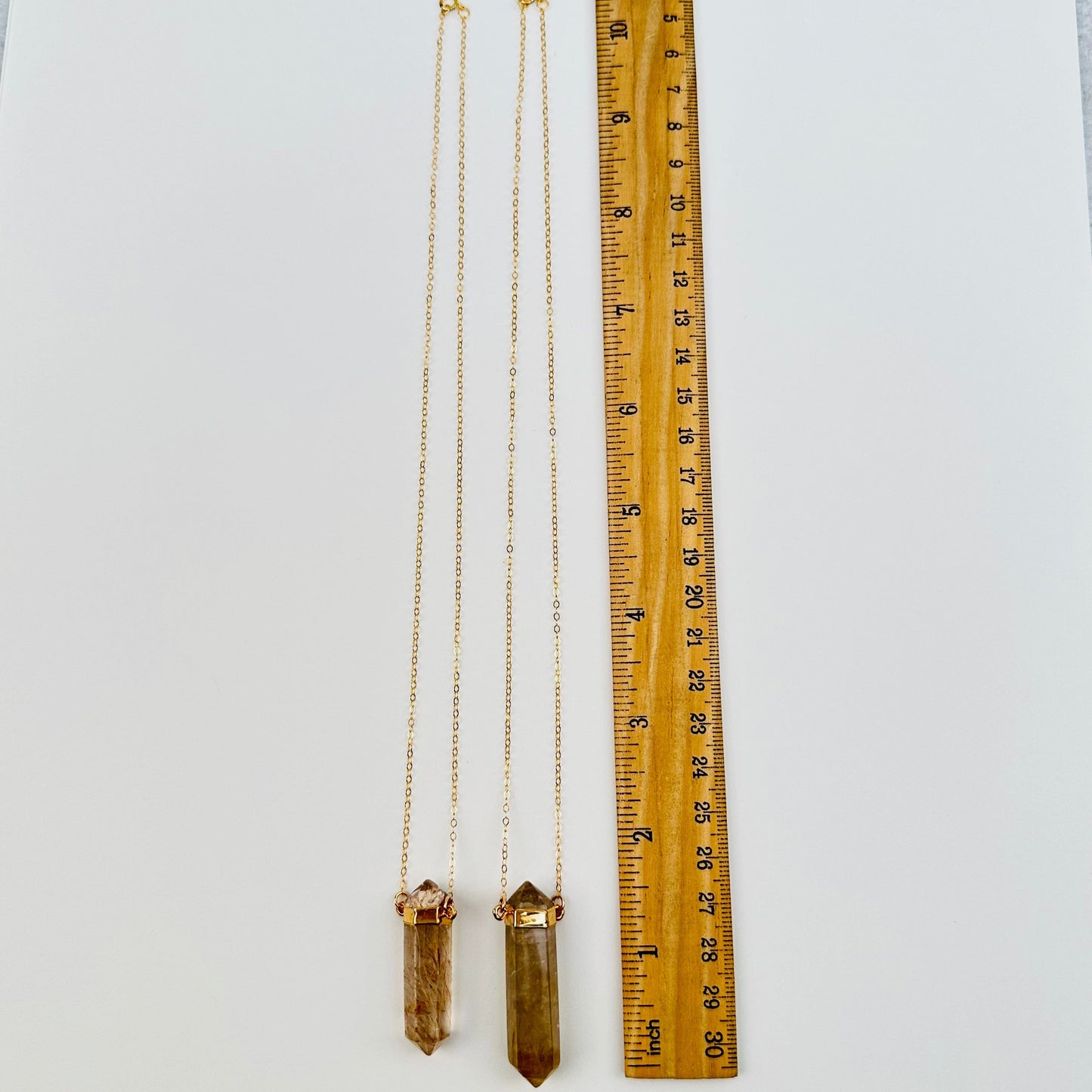 necklaces next to a ruler for size reference 