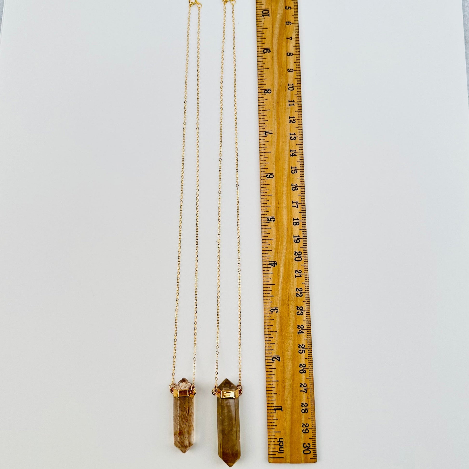 necklaces next to a ruler for size reference 