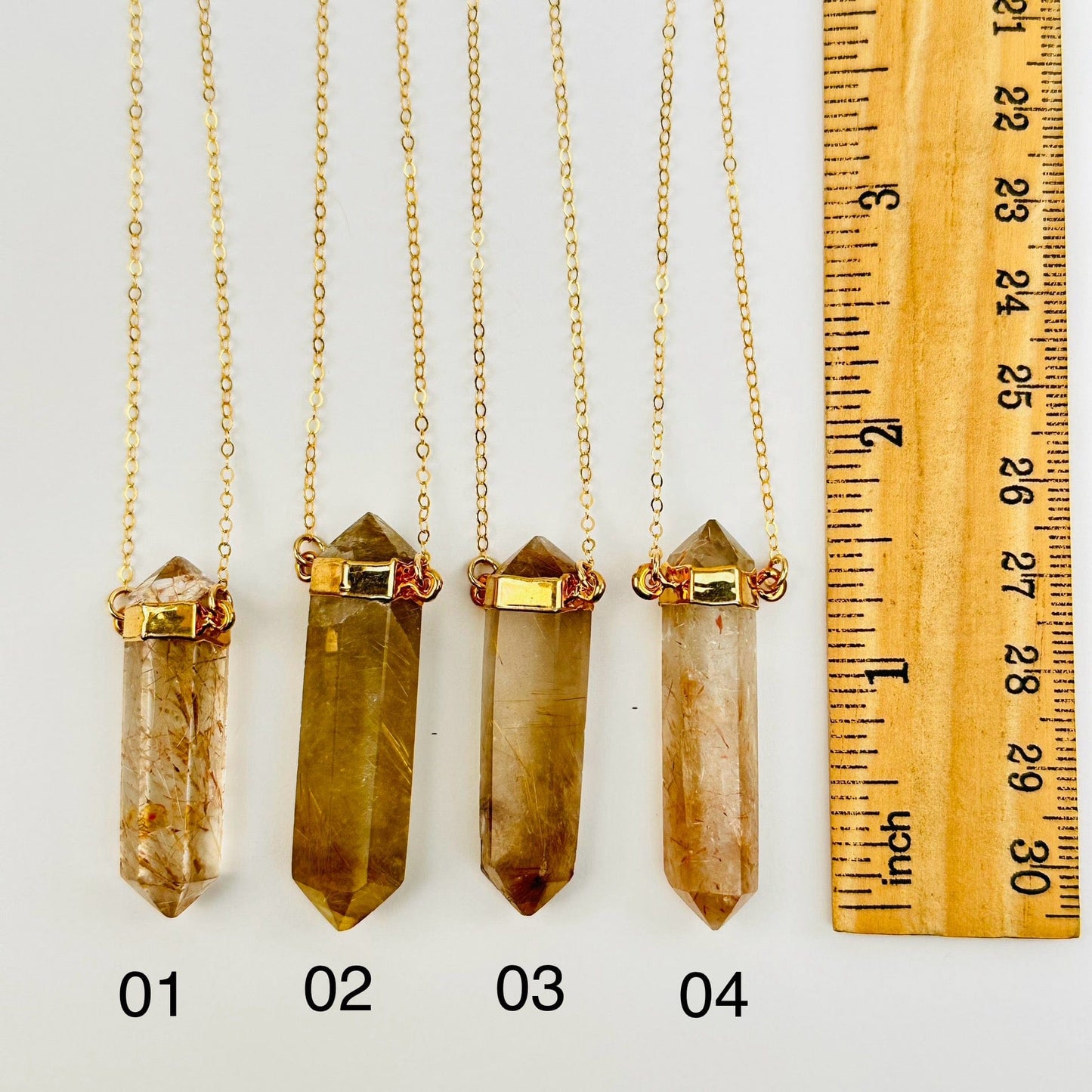 pendants next to a ruler for size reference 