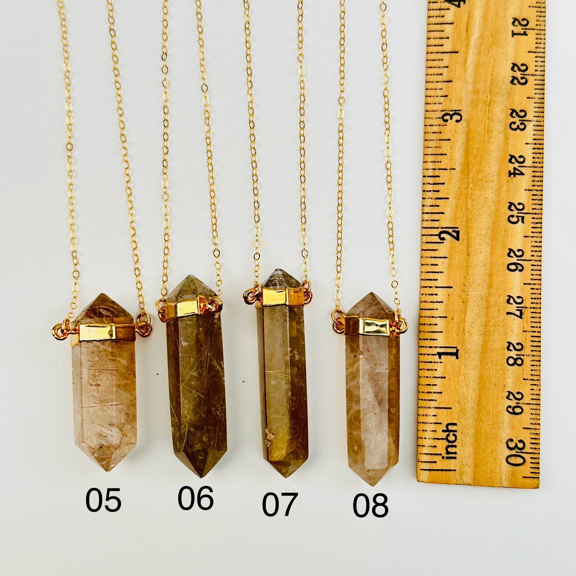 pendants next to a ruler for size reference 