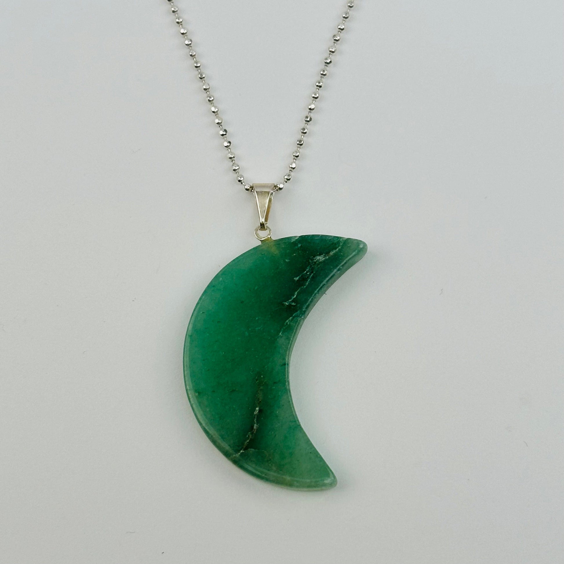 close up of a moon crescent pendant on a necklace chain to show how it hangs