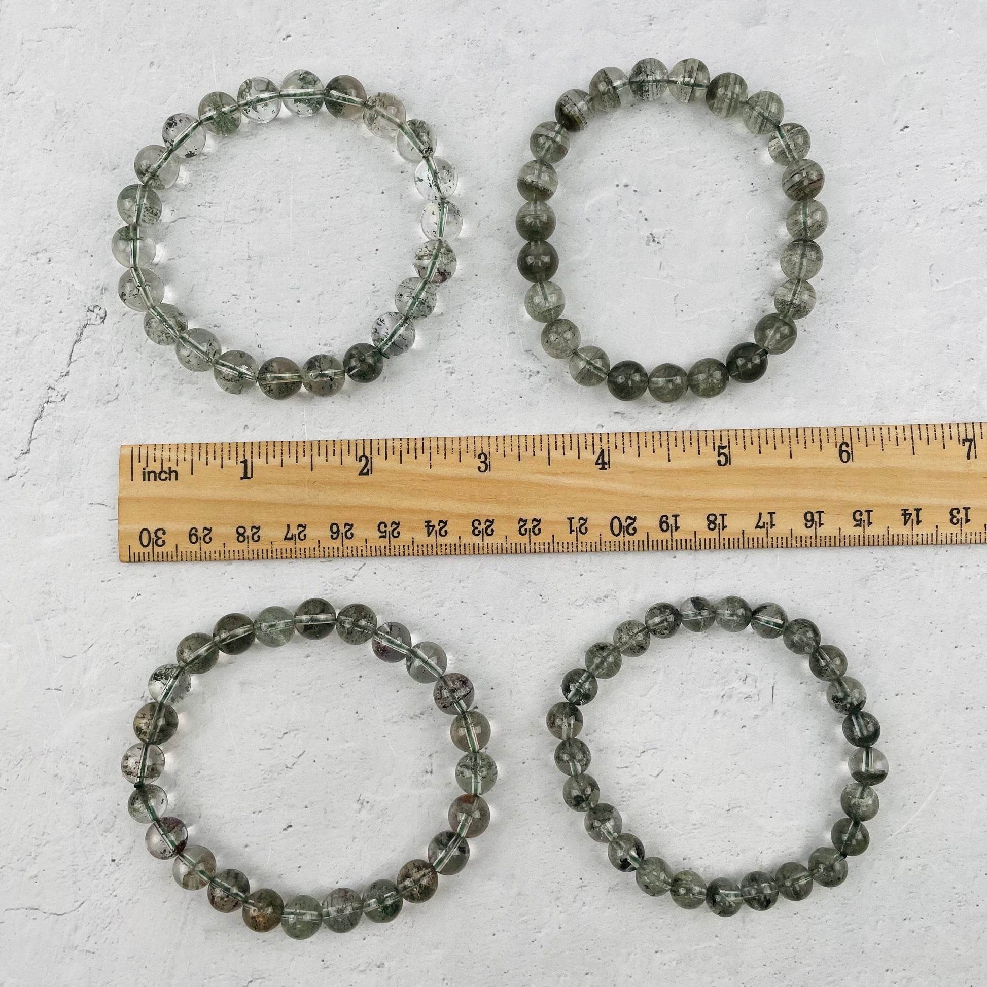 bracelets next to a ruler for size reference 