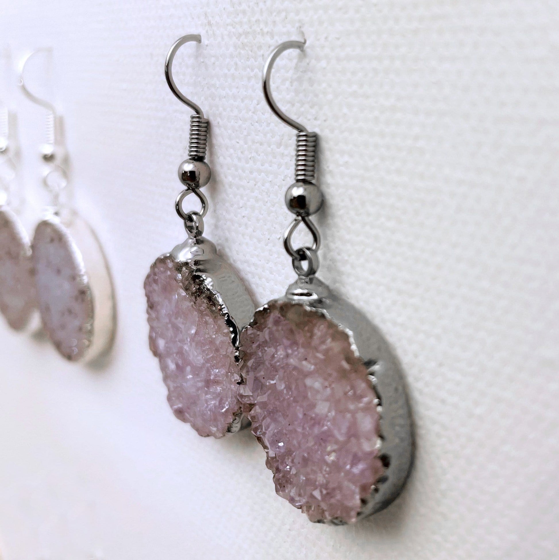 Side view of silver plated druzy round earring showing that it is plated around the edges and has silver plated earwires.