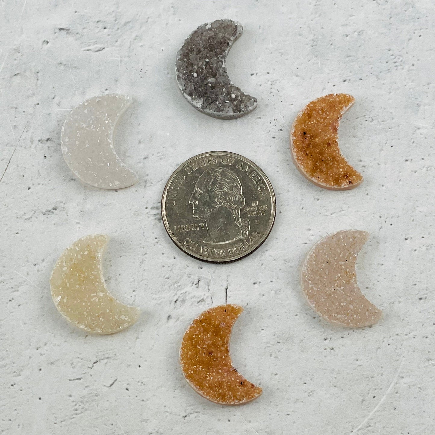 moon cabochons next to a quarter for size reference 