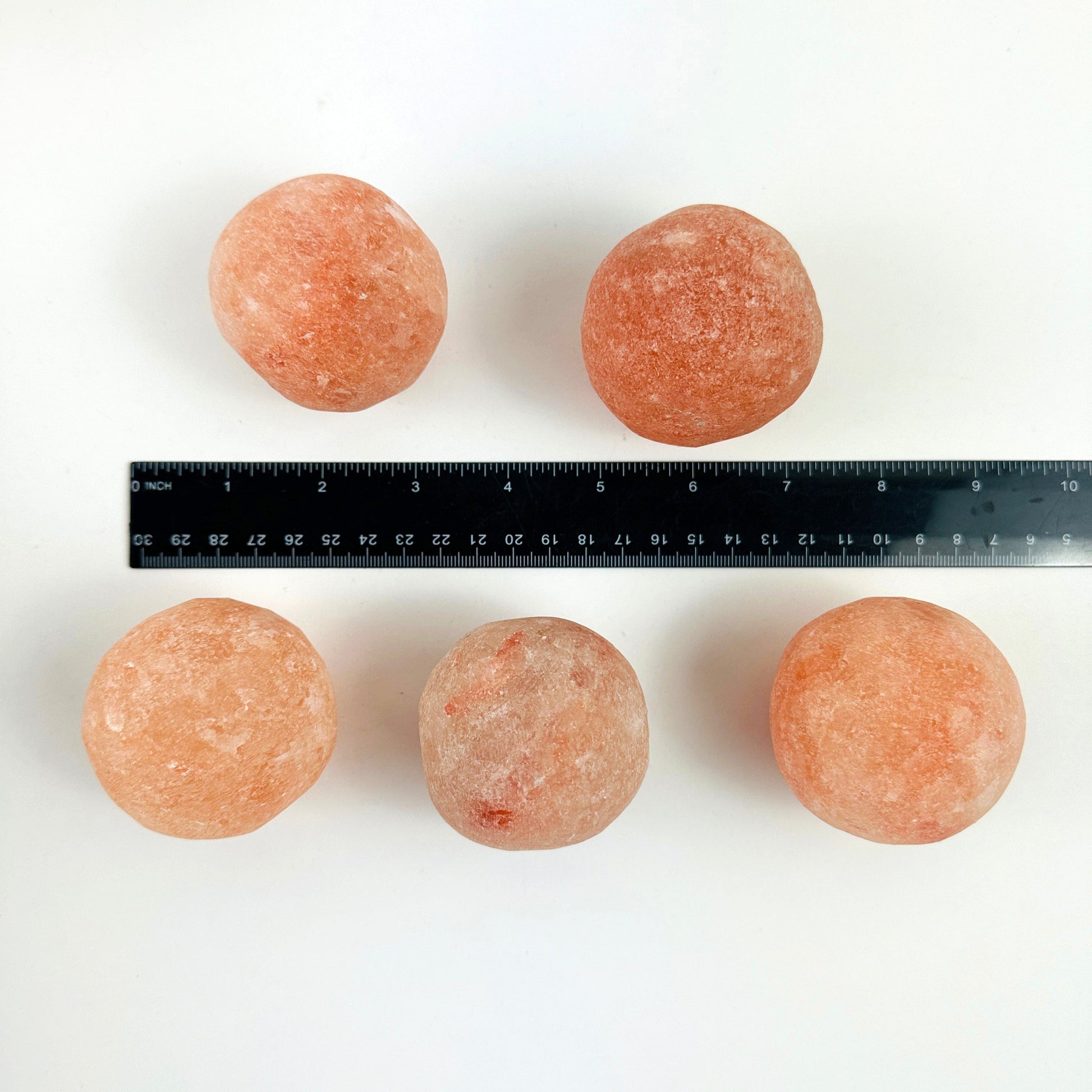 Himalayan Salt Crystal Orbs next to a ruler for size reference