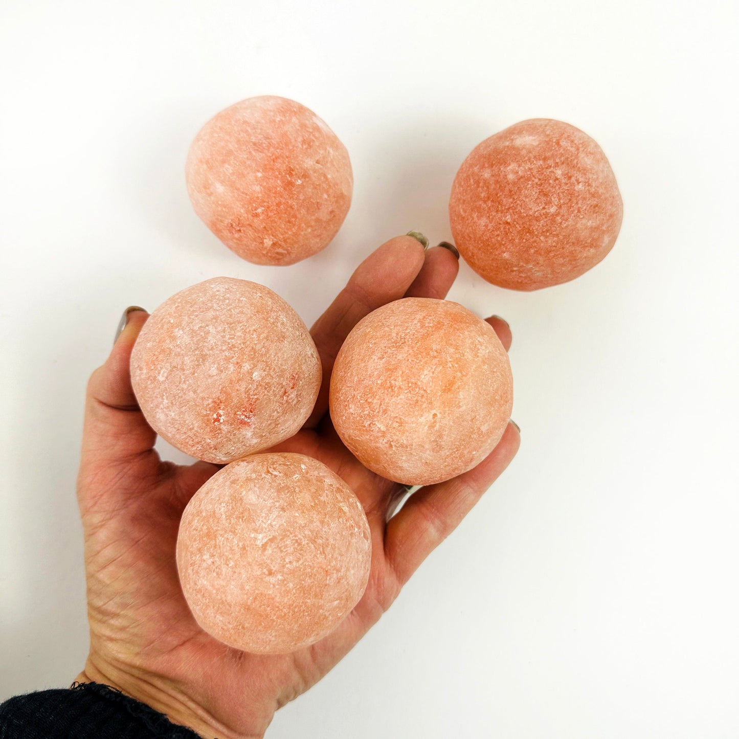 Himalayan Salt Crystal Orbs in a hand for size reference