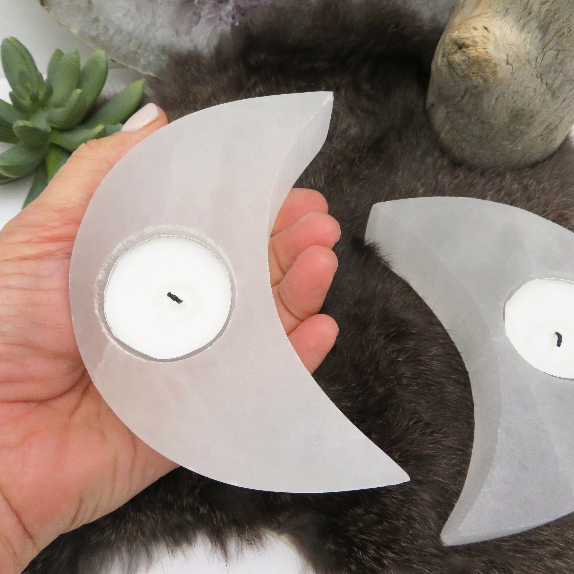 selenite crescent moon candle holder in hand for size reference