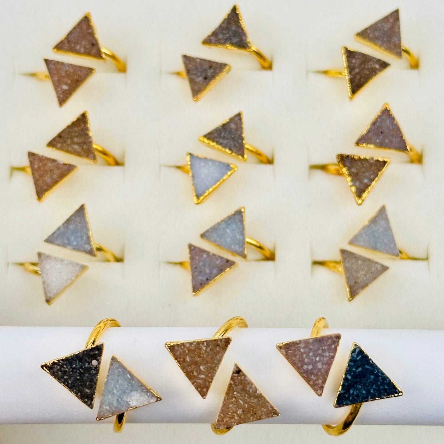 multiple crystal triangle rings displayed to show the differences in the sizes and color shades 