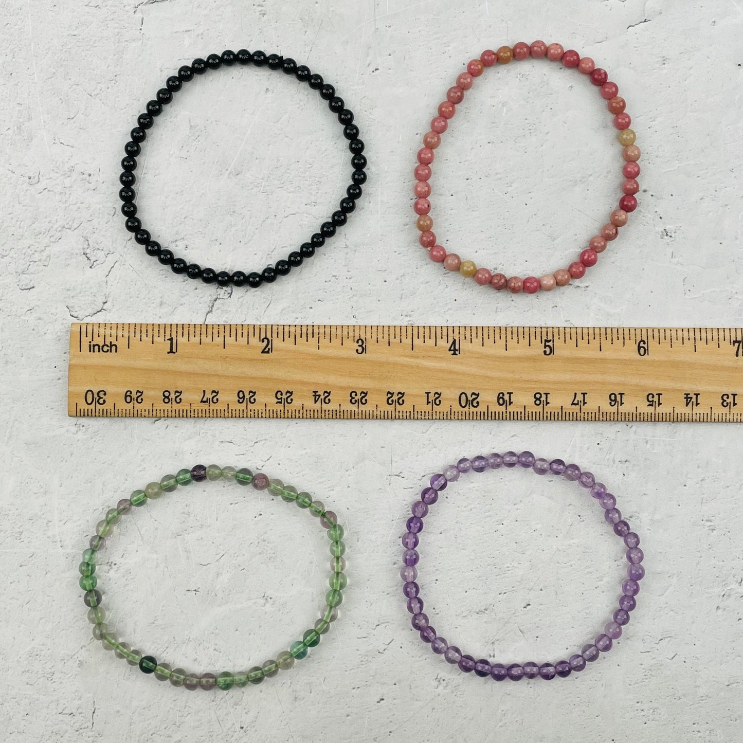 bracelets next to a ruler for size reference 