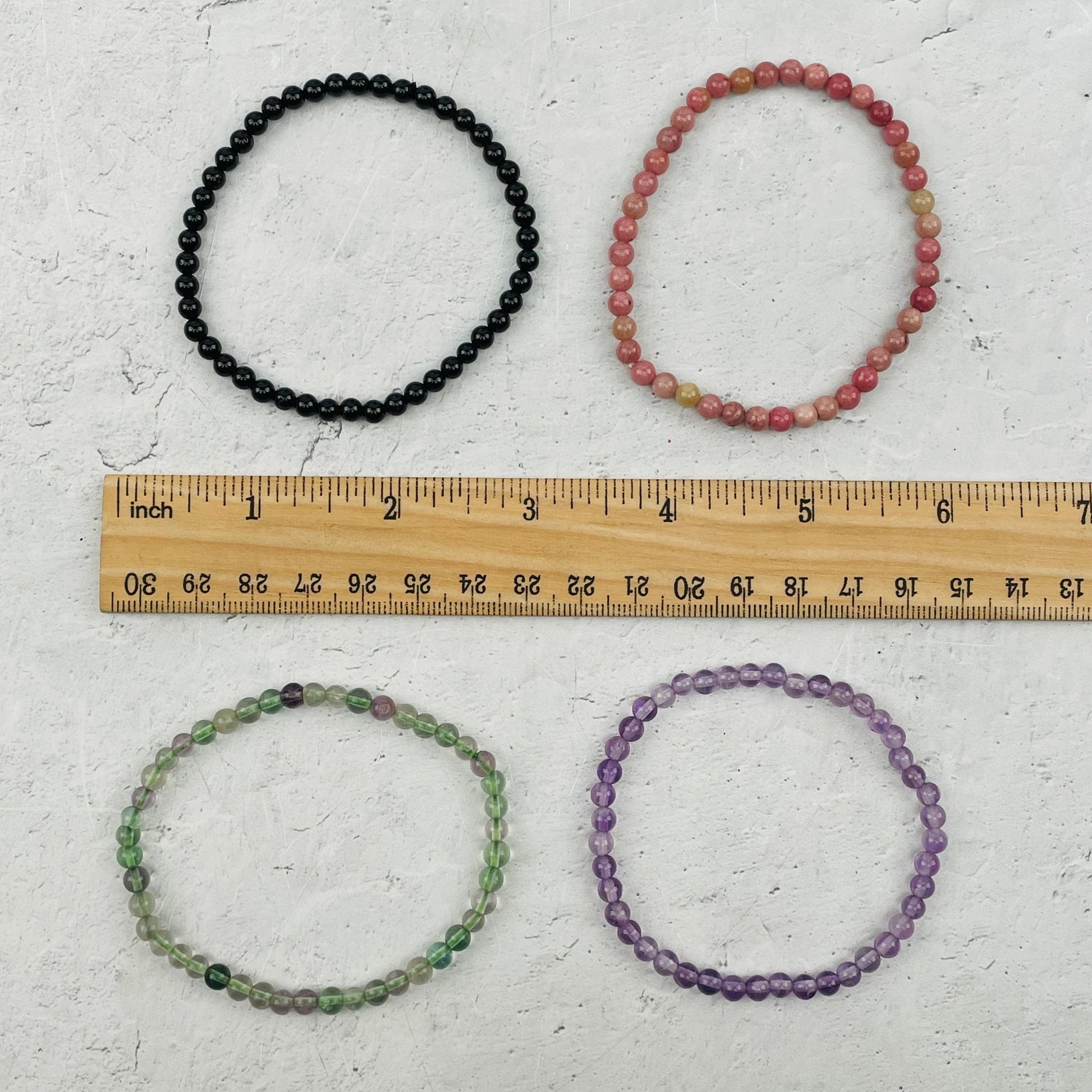 bracelets next to a ruler for size reference 