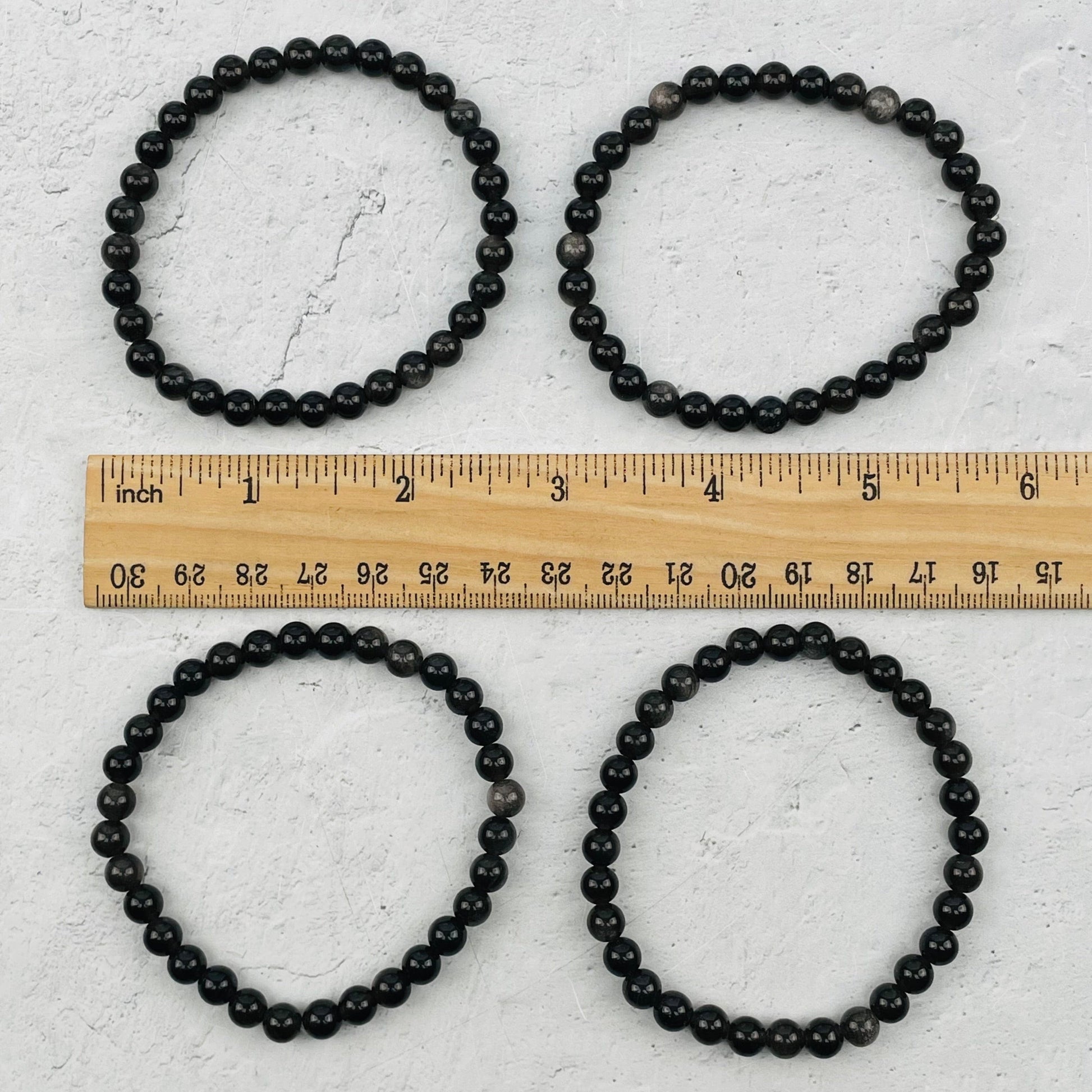 bracelets next to a ruler for size reference 