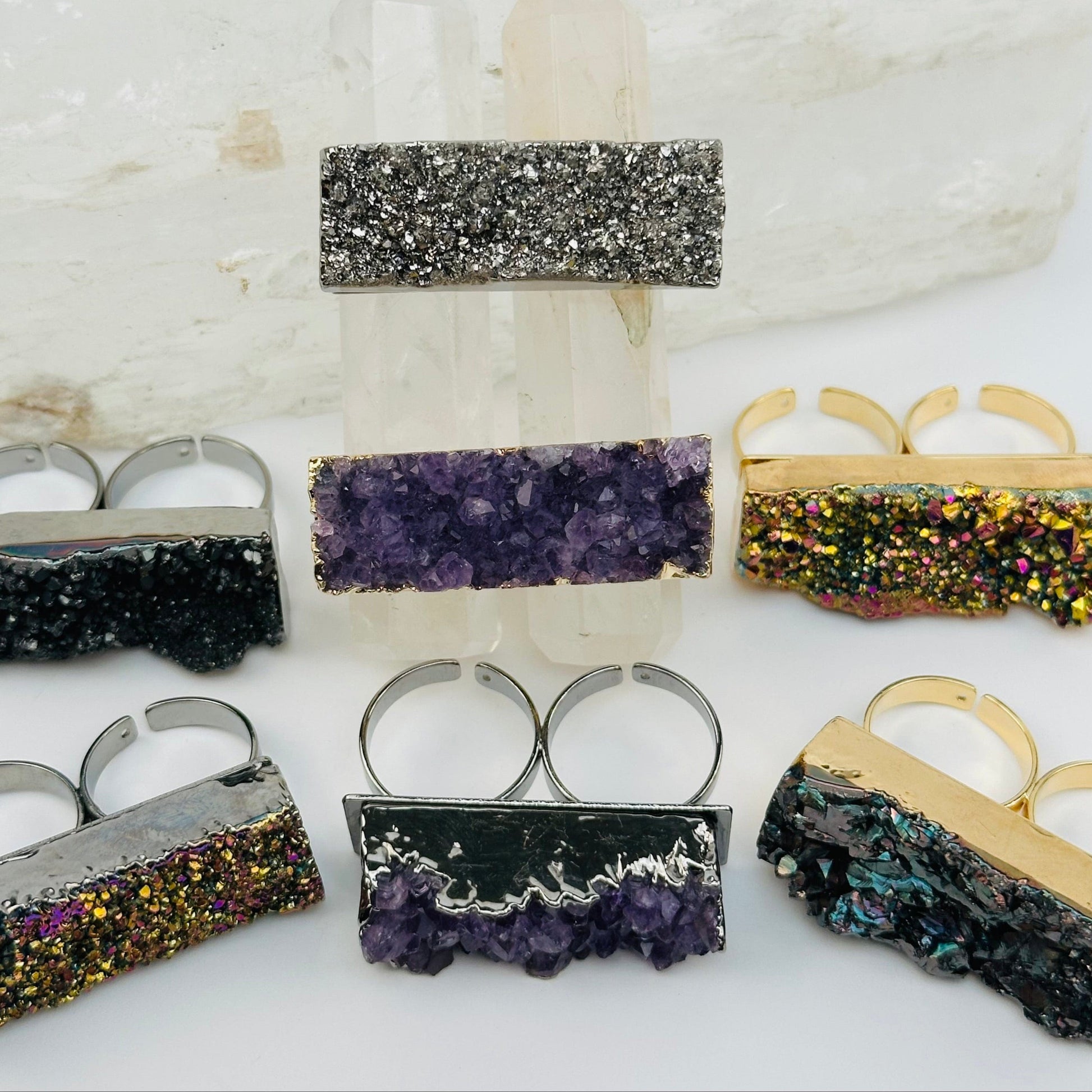 multiple titanium druzy rings displayed to show the differences in the sizes and color shades 