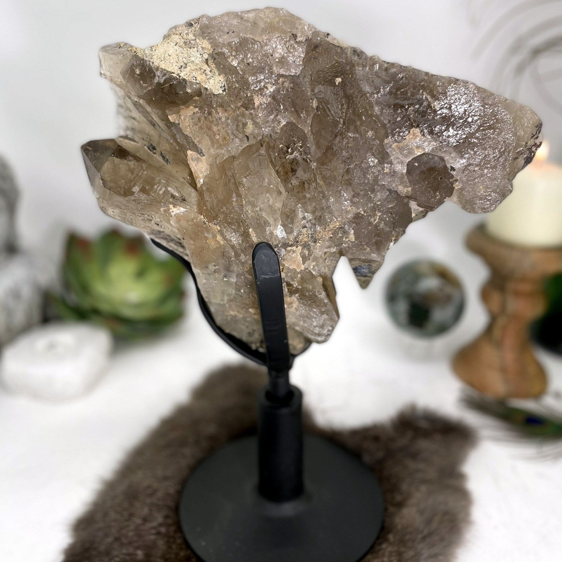 close up of smokey quartz cluster on revolving metal base for details