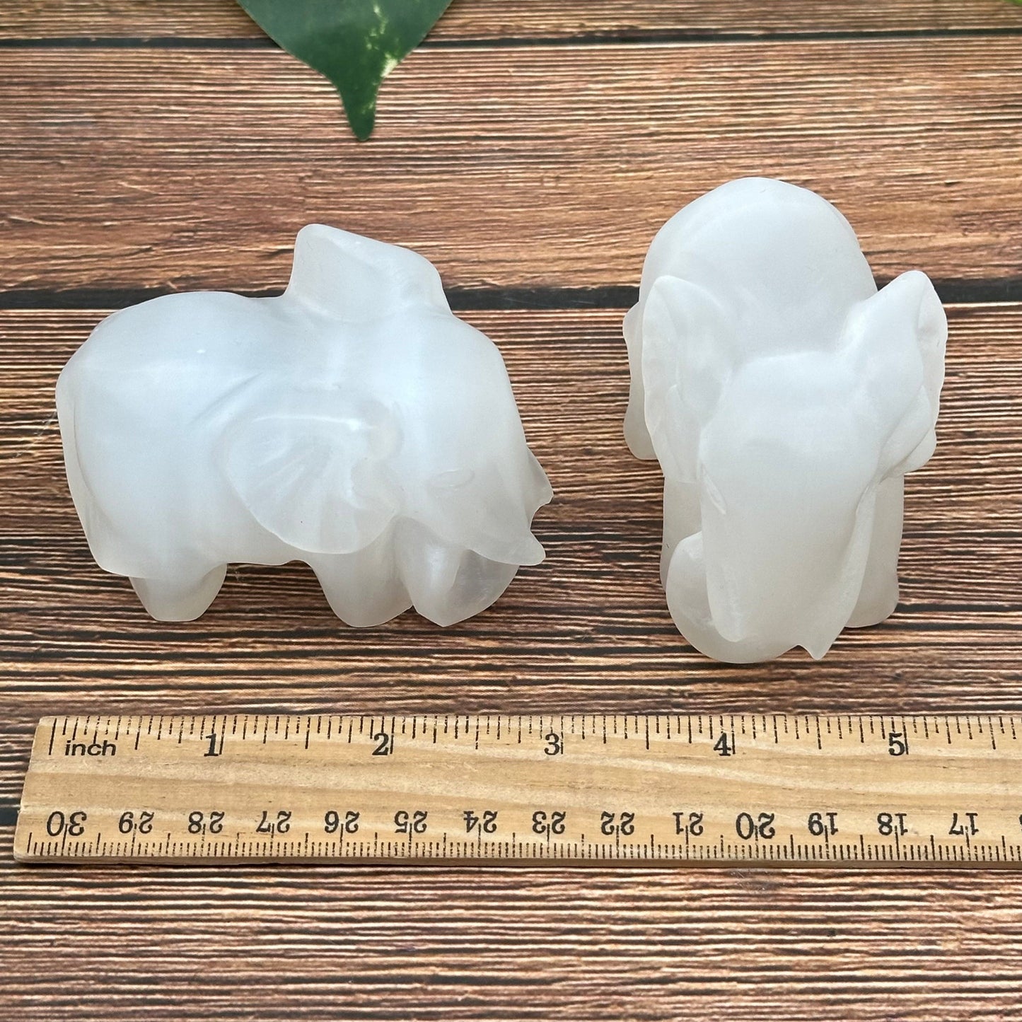 selenite elephant displayed next to a ruler for size reference 