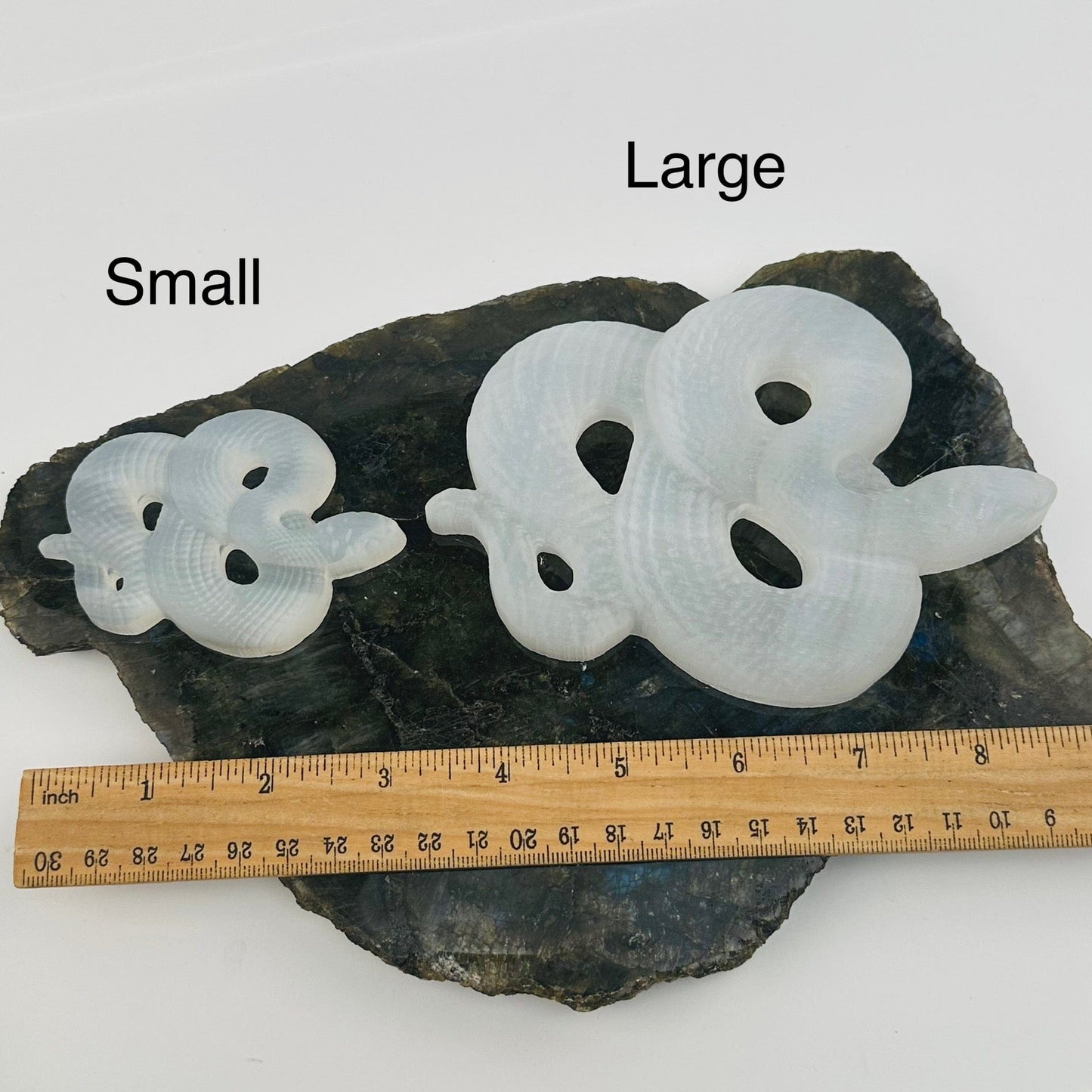 selenite crystal snakes next to a ruler for size references. available in small or large 