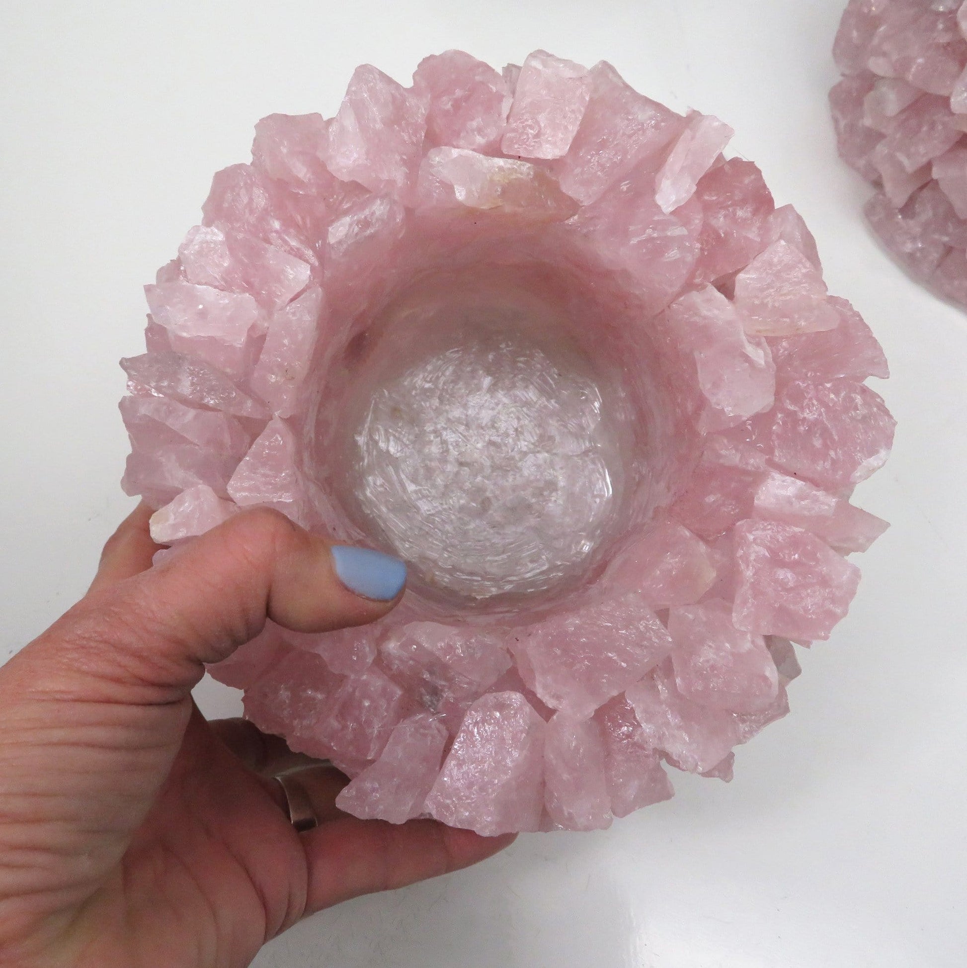 Hand holding Rose Quartz Planter Pot showing top of pot on white background