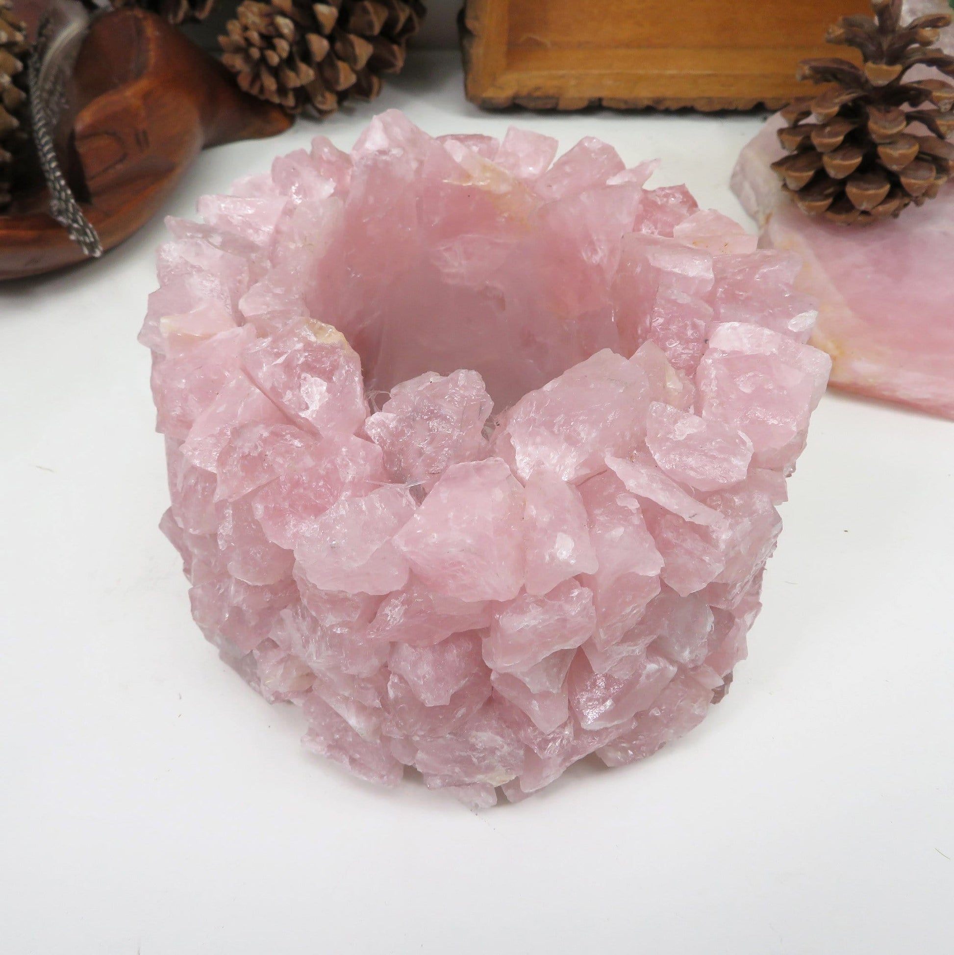 Up close shot of Rose Quartz Planter Pot with pinecones and rose quartz in the background