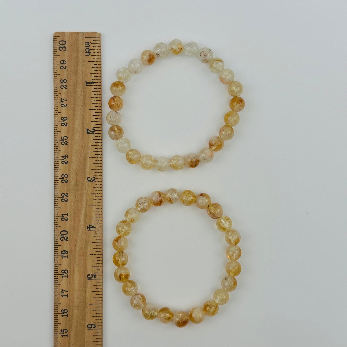 bracelets next to a ruler for size reference 