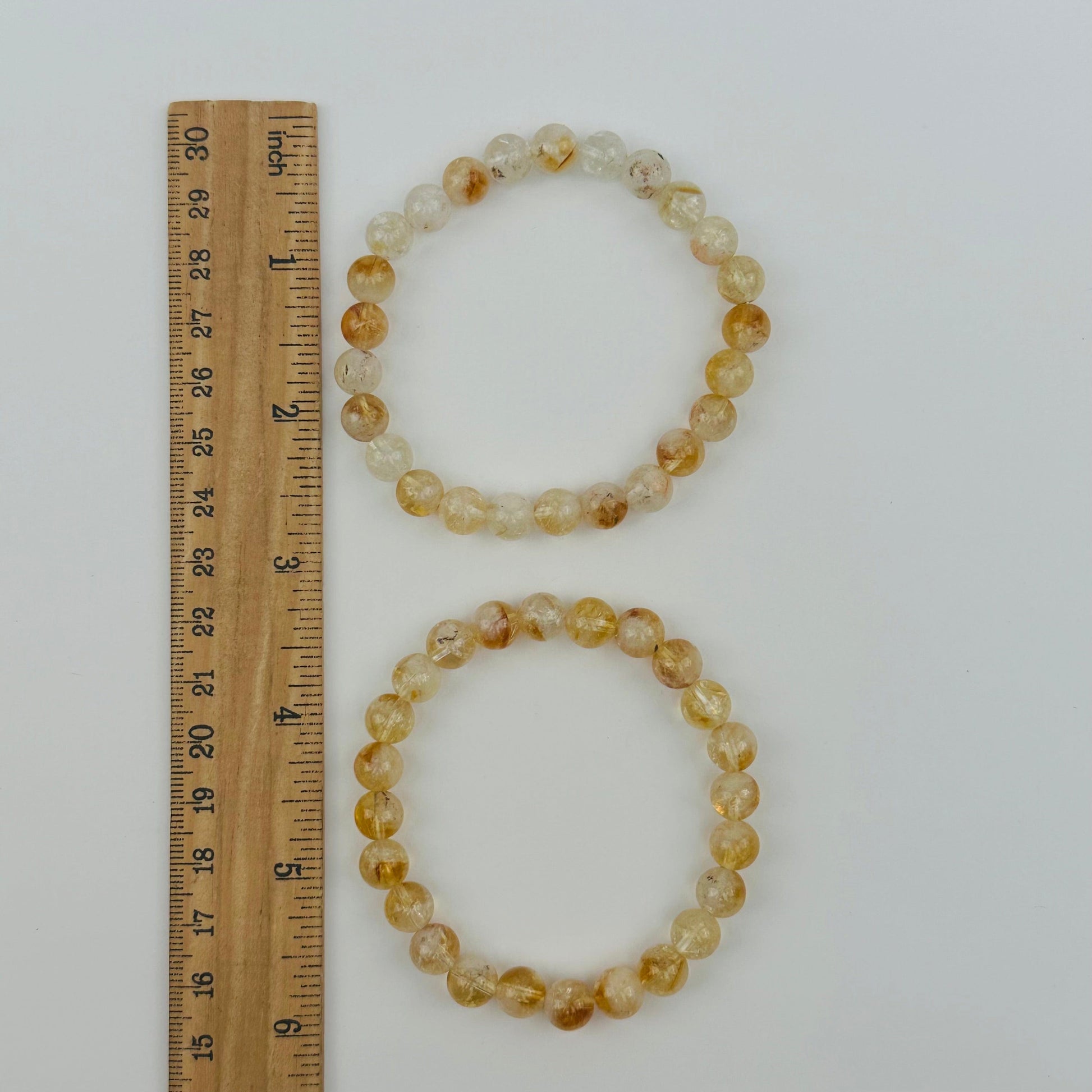 bracelets next to a ruler for size reference 