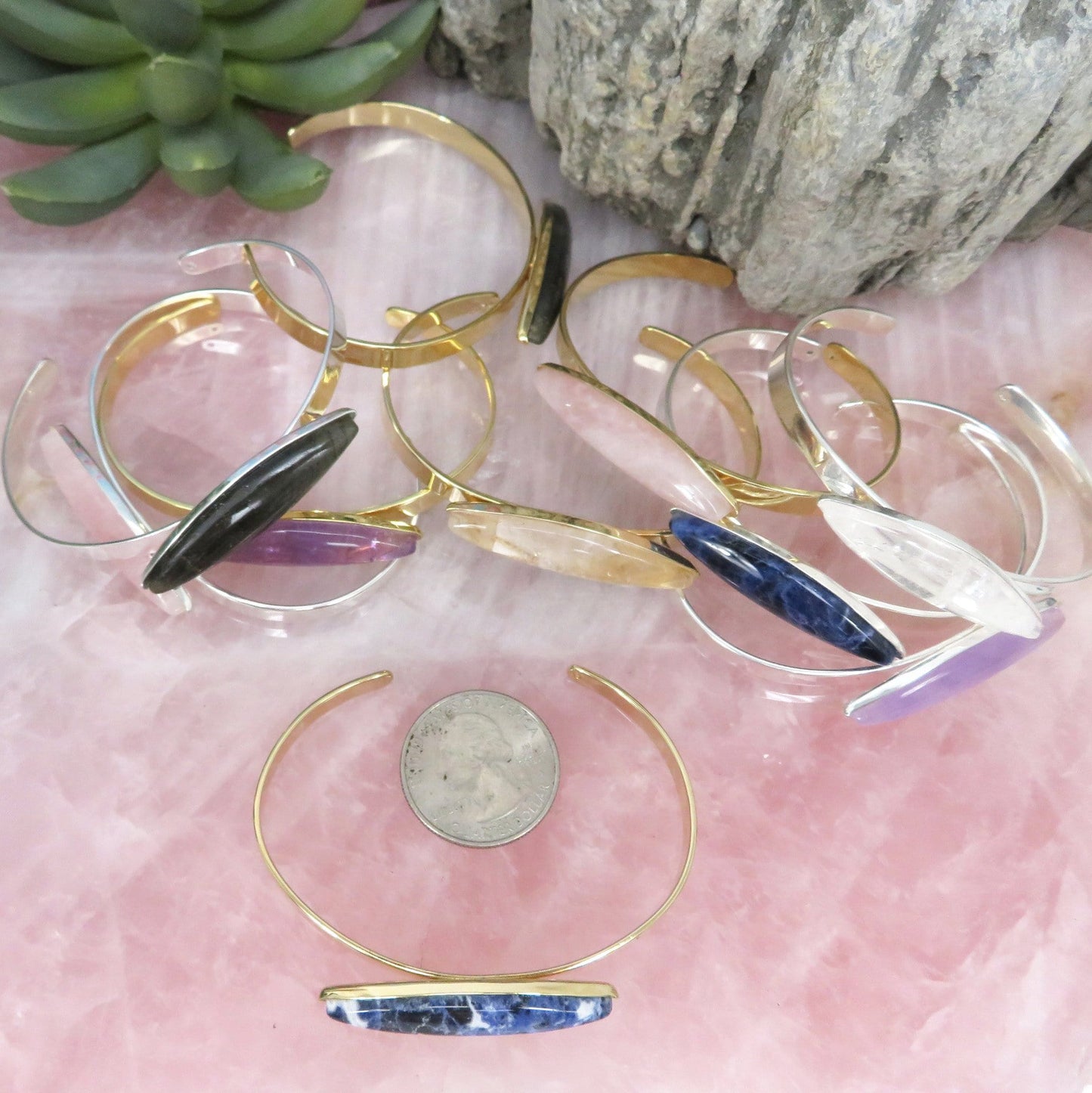 a bunch of bracelets next to a quarter