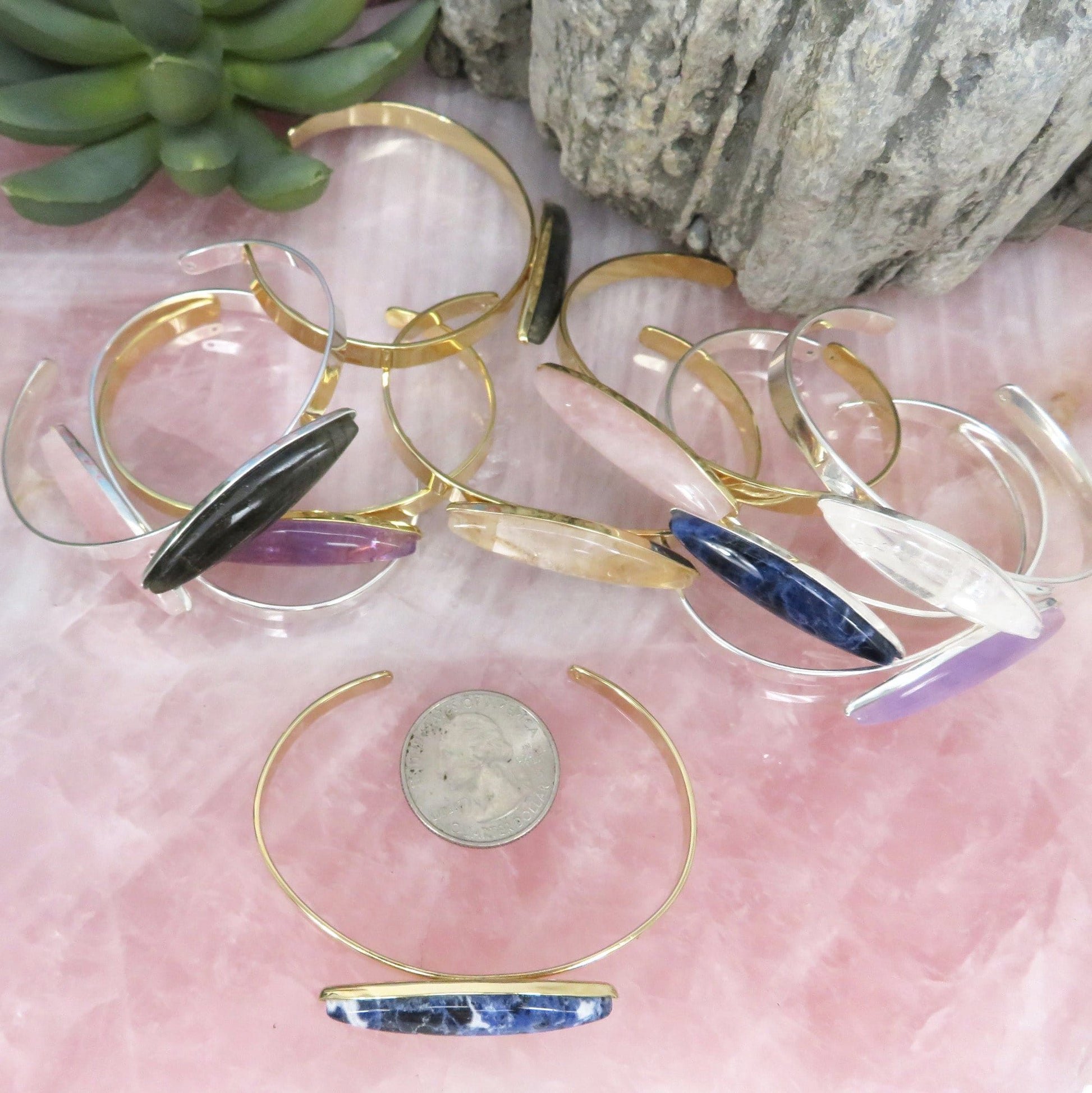 a bunch of bracelets next to a quarter